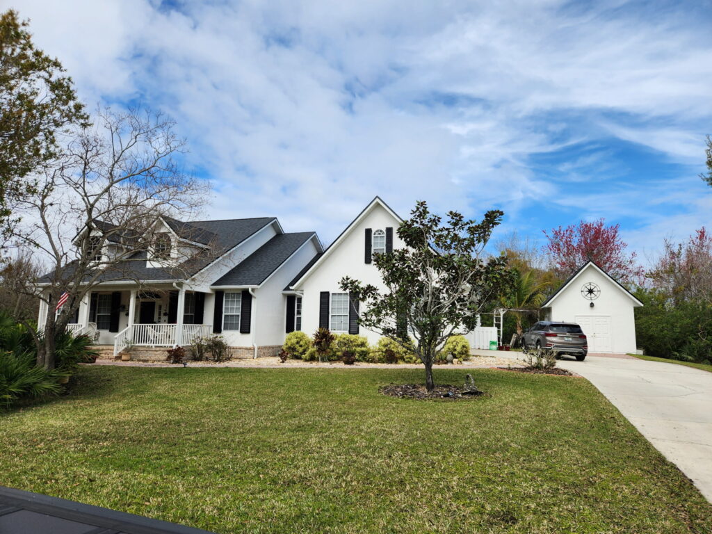 Residential exterior painting in Melbourne, FL showing a refreshed home facade with clean trim lines by Fresh Finish Custom Coatings.