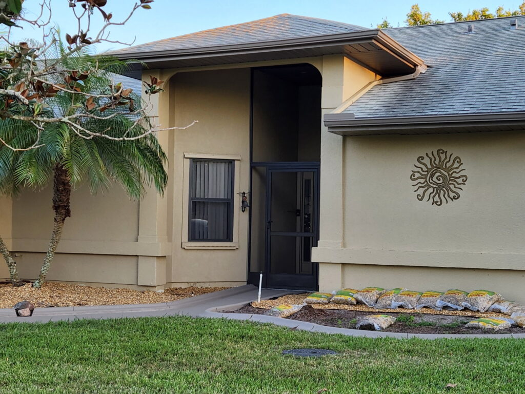Residential exterior painting in Melbourne, FL featuring stucco walls and entry door area with clean, even coverage by Fresh Finish Custom Coatings.