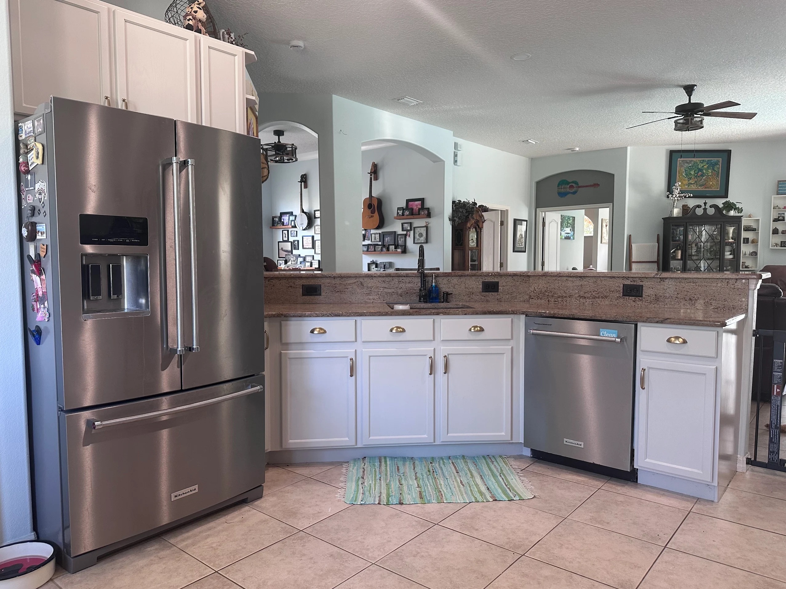 Freshly painted white kitchen cabinets with granite countertops and stainless steel appliances in Melbourne Florida home